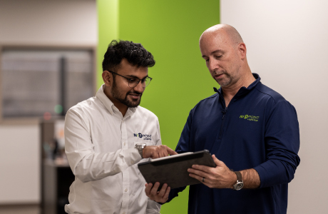 team members reviewing data in iPad